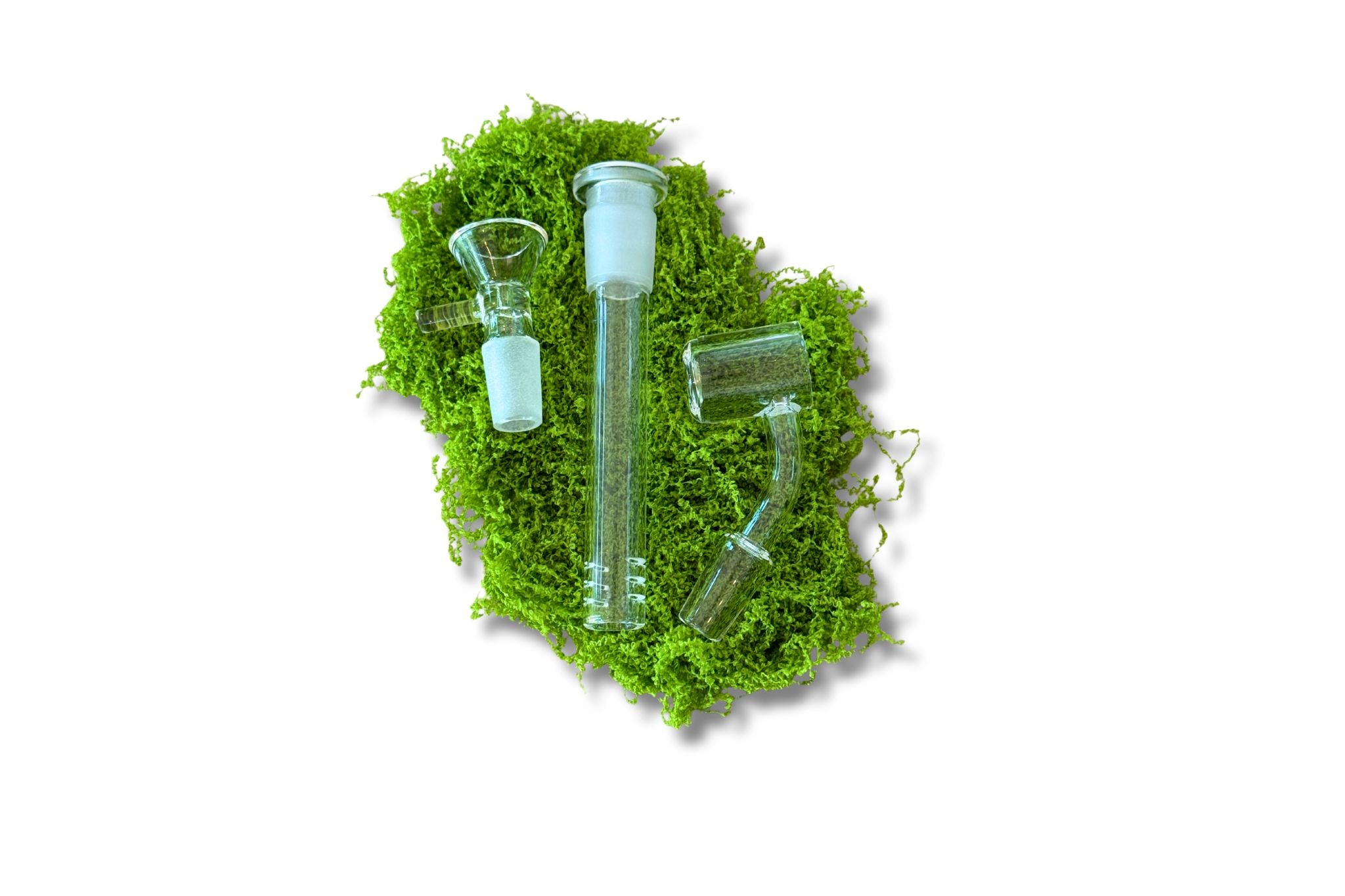 Set of glass smoking accessories on a bed of green moss