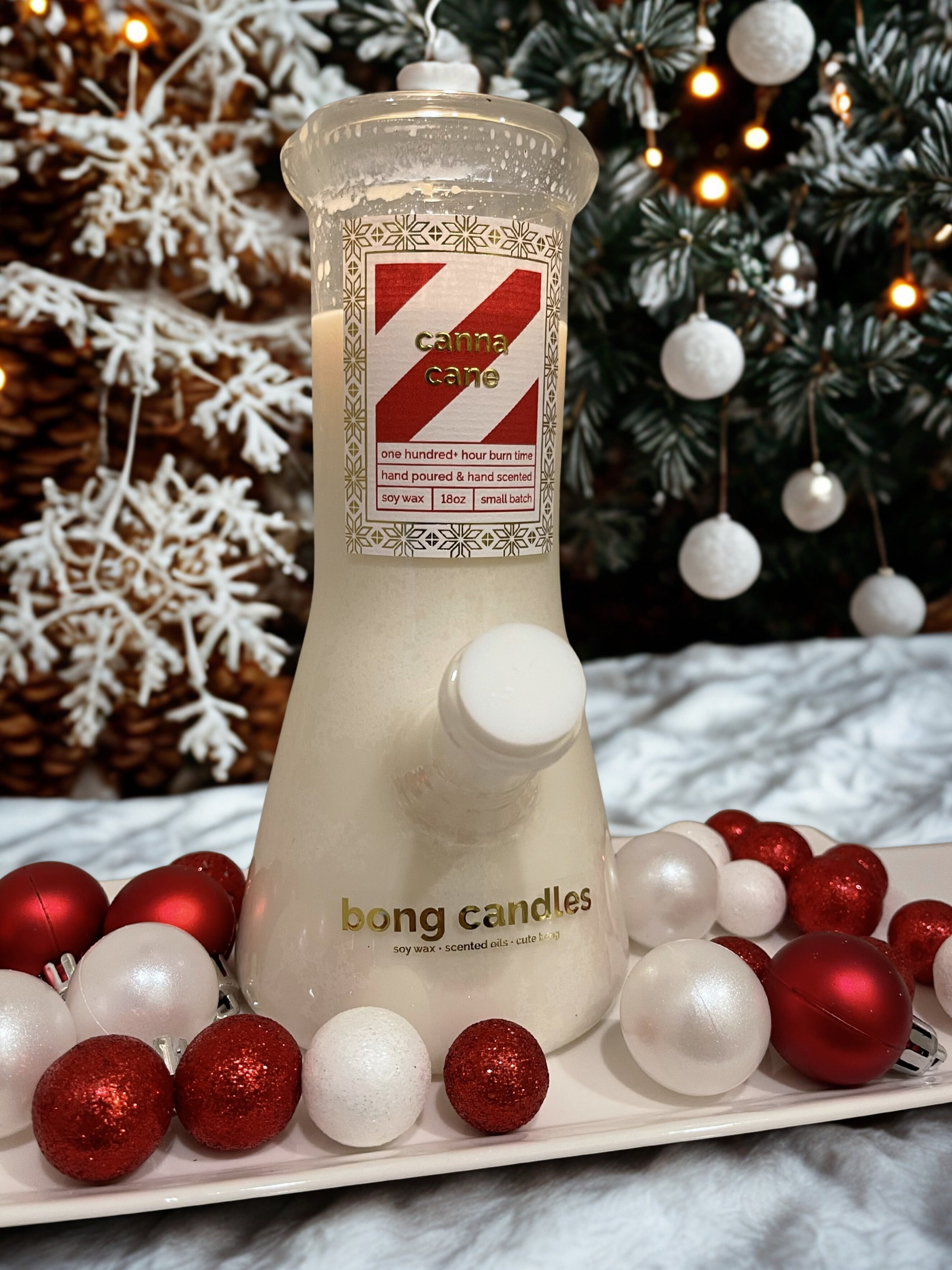 canna cane bong candle in front of a Christmas tree with ornaments