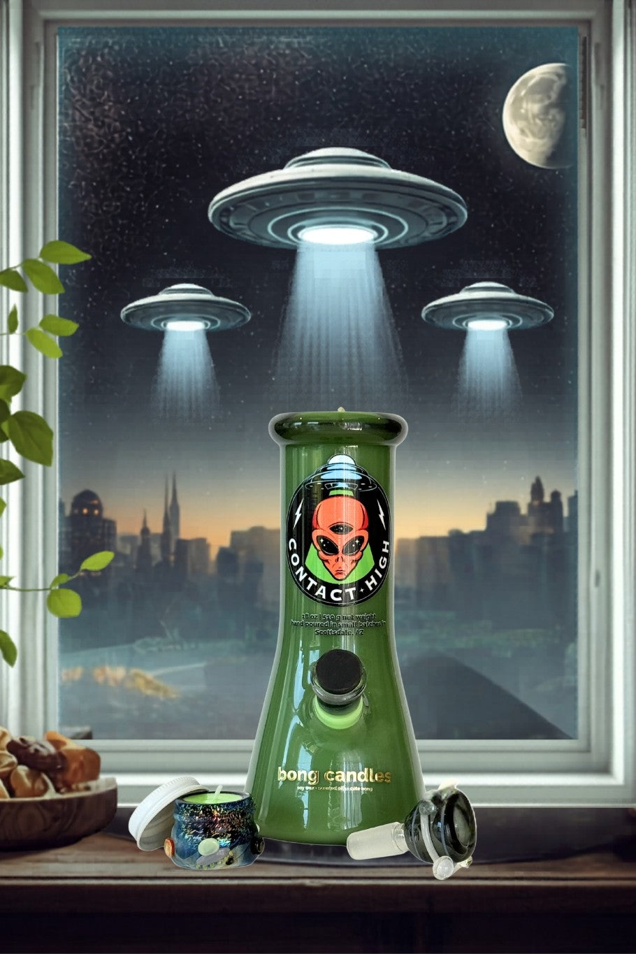bong candles contact high, Green candle with alien design in front of a window showing UFOs over a cityscape.