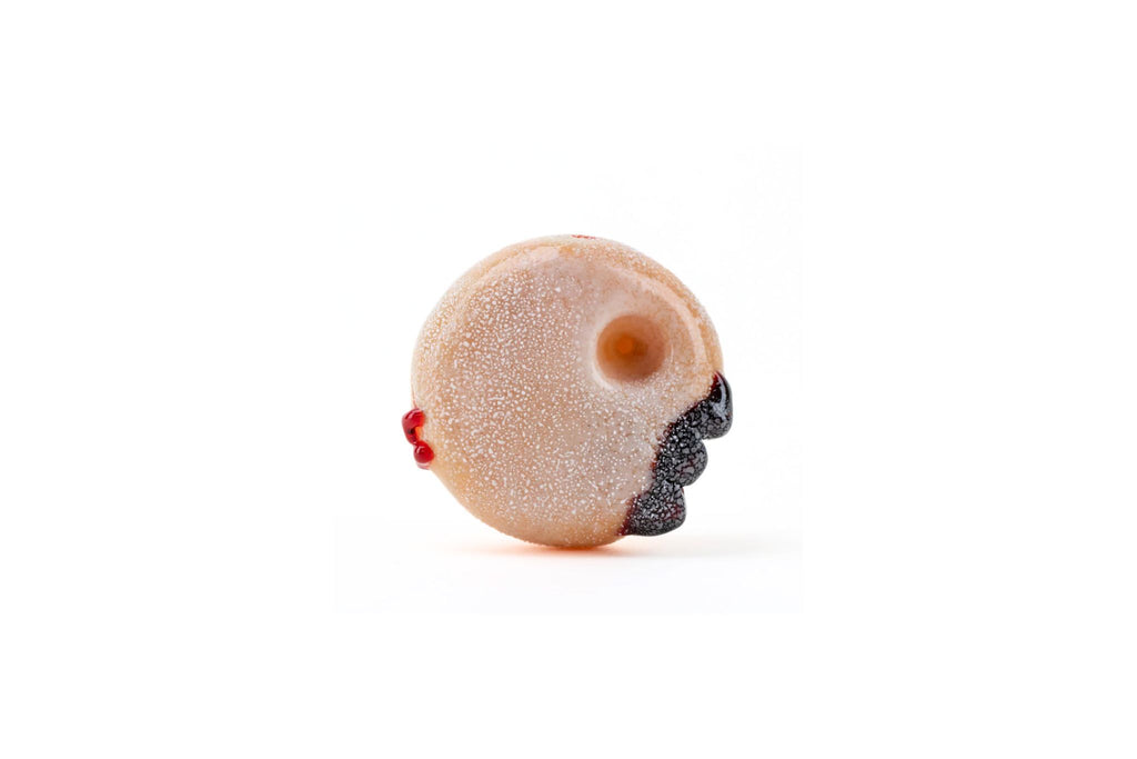 jelly roll Donut-shaped glass pipe with a face design on a white background