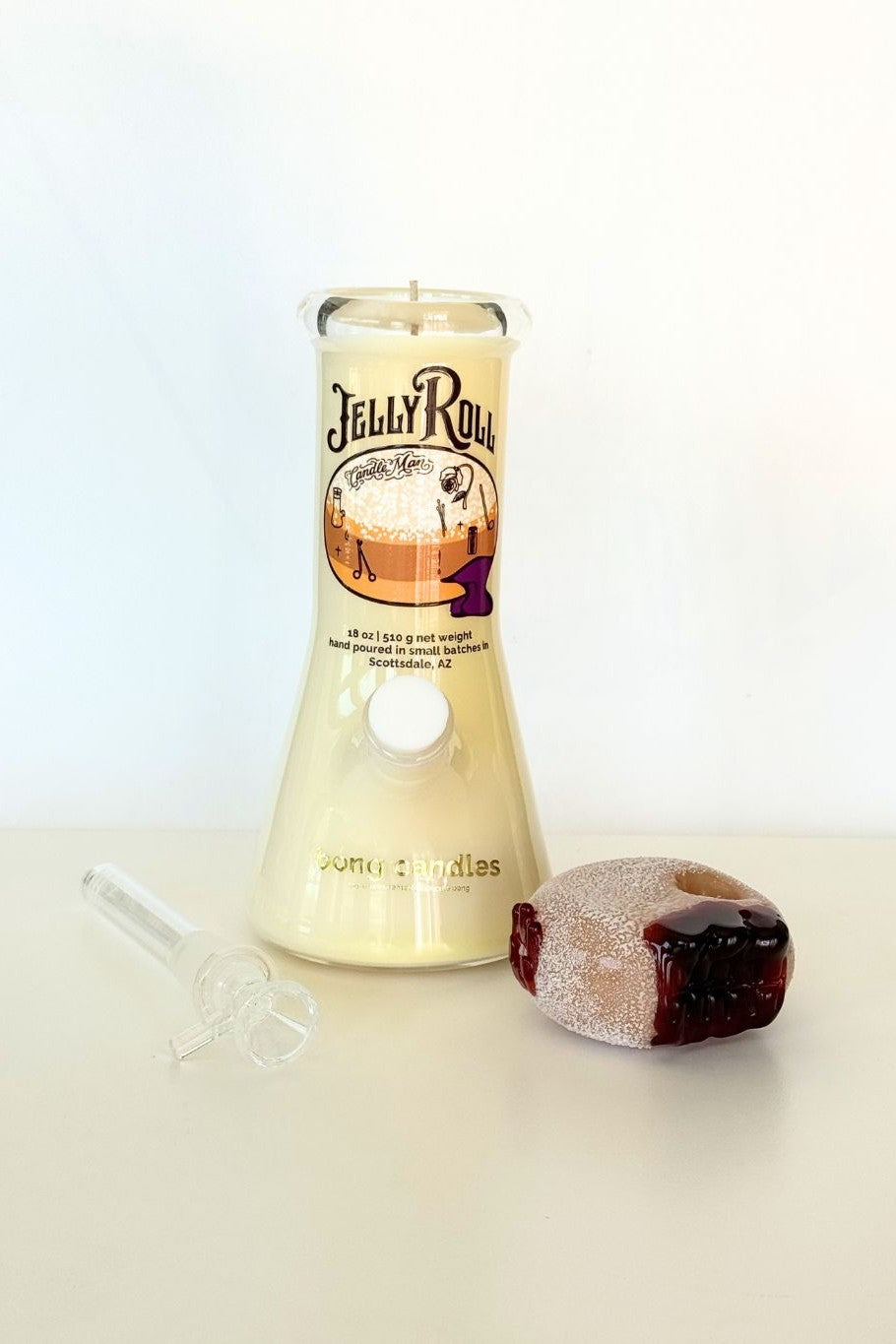 Jelly Roll candle with a jelly roll next to it on a light background