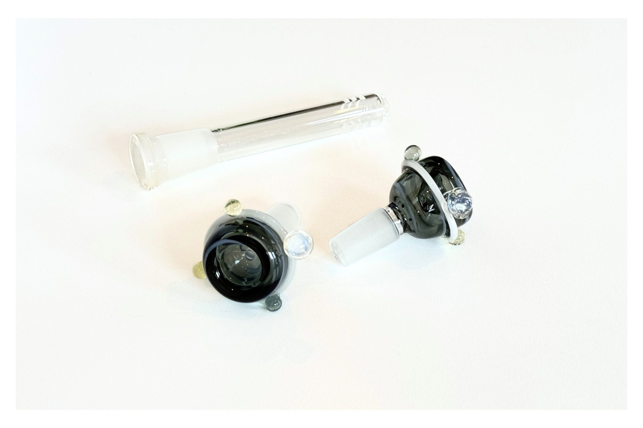 Two black and silver handblown glass downstem + bowls on a white background